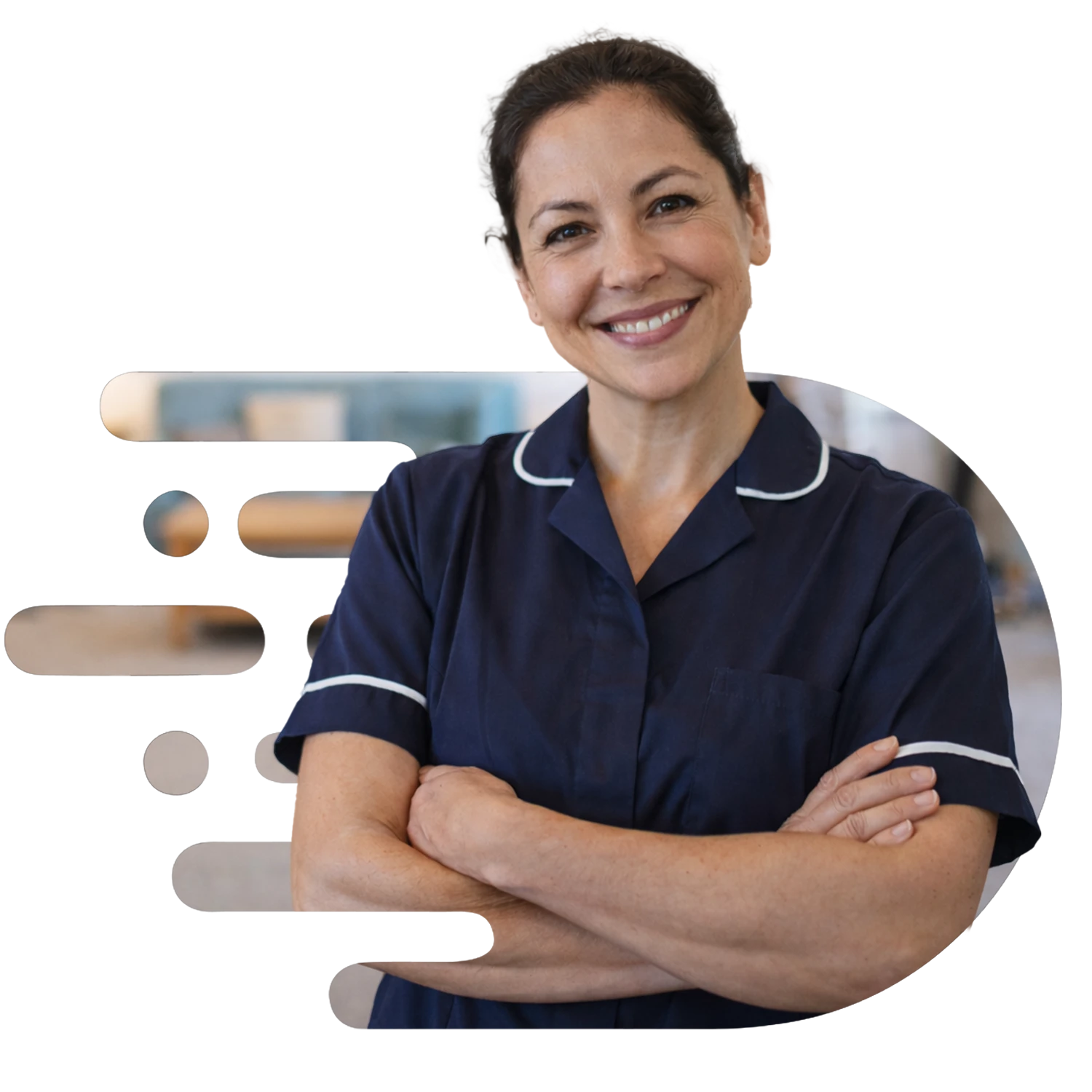 Friendly healthcare assistant in navy uniform standing with arms crossed and smiling at the camera in a bright retirement home lounge, with elderly residents softly blurred in the background.